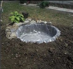 an outdoor fire pit in the middle of a yard with gravel and rocks around it