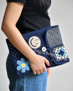 a woman is holding a crocheted purse with buttons and beads on the side