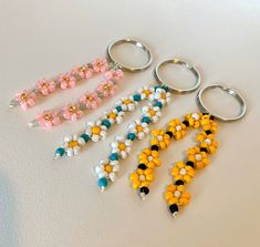 six key chains with beads on them sitting next to each other in different colors and shapes