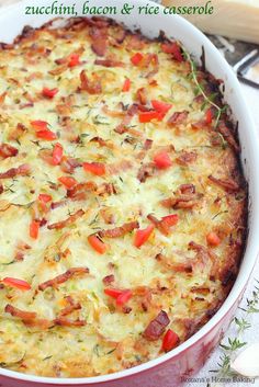 a casserole with cheese and vegetables in a red dish on a white tablecloth