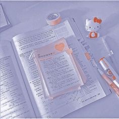 an open book with hello kitty on it and other items next to it in japanese