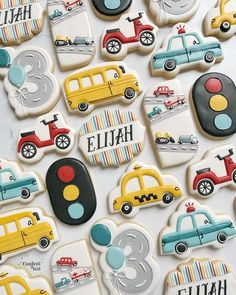 decorated cookies with cars and trucks are displayed on a table in front of the camera