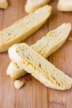 several pieces of bread sitting on top of a wooden cutting board next to each other