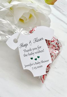 candy canes in a bag with a tag that says, hugs and kisses thank you for the baby wishes