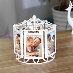 a white photo frame sitting on top of a wooden table