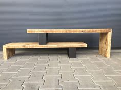 a wooden bench sitting on top of a sidewalk