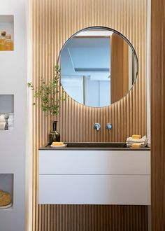 a bathroom with a sink, mirror and shelves on the wall next to each other