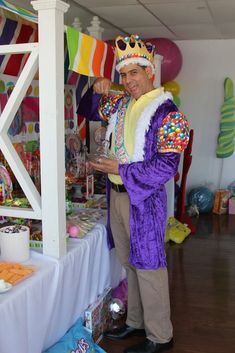 a man in a clown costume standing next to a table