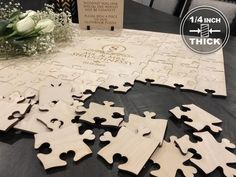 the wooden puzzles are laid out on the table with flowers in front of them