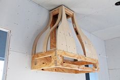 a light fixture made out of plywood is hanging from the ceiling in a room