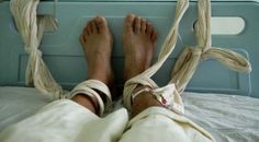 a person's bare feet on top of a hospital bed