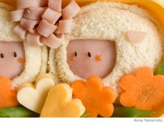 two little pigs sitting in the middle of some bread with flowers and leaves around them