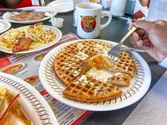 people eating waffles at a table with coffee and other breakfast foods on it