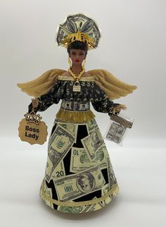 a figurine made out of dollar bills and wearing a hat with gold trim