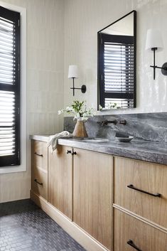 a bathroom with two sinks and wooden cabinets