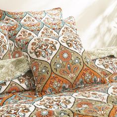 an orange and blue bed spread with pillows