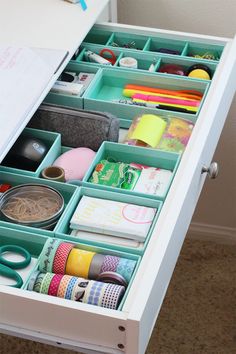 an organized drawer with tape, scissors and other crafting supplies in it's drawers