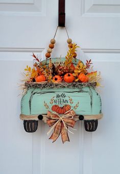 a blue truck with pumpkins in it hanging from the front door