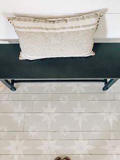 a pair of shoes sitting on top of a black bench next to a white wall