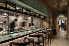 the chefs are preparing their meals in the large kitchen at the restaurant's bar