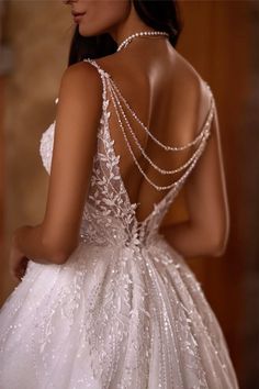 the back of a woman's wedding dress with beaded details and pearls on it