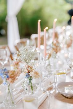 the table is set with flowers and candles