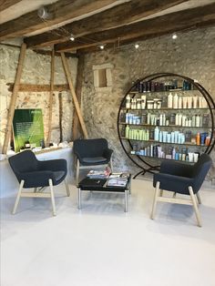 two chairs and a coffee table in a room with stone walls, exposed beams and exposed ceiling