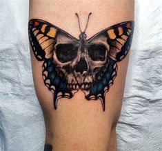 a skull and butterfly tattoo on the leg