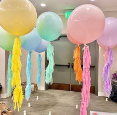 balloons with tassels and streamers are hanging from the ceiling in an office