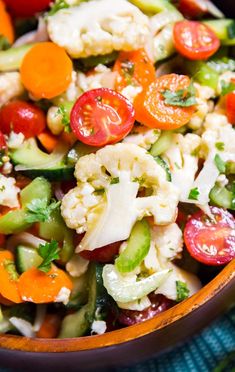 a salad with tomatoes, cauliflower, cucumbers and other veggies