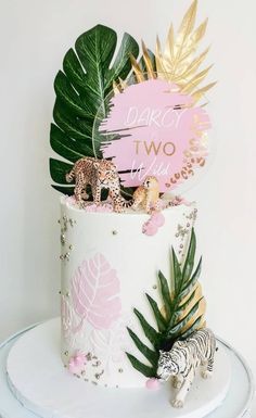 there is a cake decorated with tropical leaves and animals