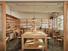 an empty room with wooden shelves and tables in the center, along with several chairs