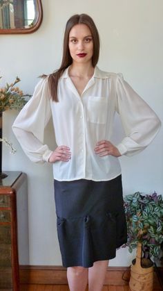 "Beautiful classic detailed vintage blouse by Jack Mulqueen. Vintage is 1980s or 1990s. Voluminous full sleeves, finely gathered at shoulders, and at the 1 1/2\" cuffs. Tiny mother of pearl buttons at cuffs. Yoked shoulders and back. Gathered at front yoke. Single patch pocket with eight rows of top stitching detail. White V neck notched collar with five rows of top-stitching. Top stitching down the front with four tiny mother of pearl buttons. Semi sheer ivory polyester crepe fabric. Labelled: Classic Blouse With Balloon Sleeves And Button Cuffs, Vintage Long Sleeve Office Tops, Vintage Long Sleeve Blouse For Fall, Vintage Long Sleeve Tops For Office, Classic Formal Blouse With Balloon Sleeves, Long Sleeve Blouse For Vintage Fashion In Fall, Long Sleeve Blouse For Fall Vintage Fashion, Vintage Fitted Tops With Gathered Sleeves, Classic Balloon Sleeve Blouse For Fall