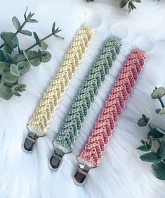 three crocheted key fobs on a white furnishing next to plants