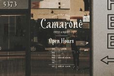 the front window of a coffee shop that sells camarone coffee and bakery's open hours