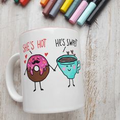 there is a coffee cup with two donuts on it next to crayons