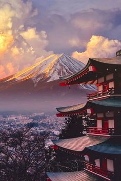 the sun is setting behind a mountain with pagodas on it's sides and snow capped mountains in the background