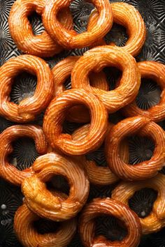 several pretzels sitting on top of each other in a black tray with holes