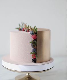 a pink cake with berries and leaves on top