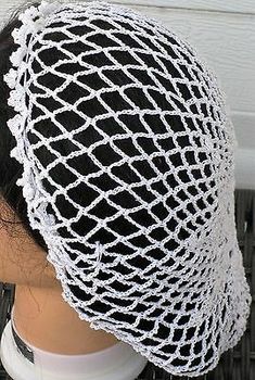 a mannequin head wearing a black and white netted hat on it's head