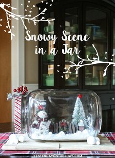 snow scene in a jar with christmas decorations on the table and text overlay that reads, snowy scene in a jar