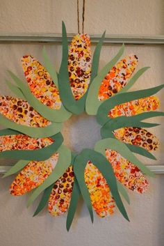 a paper plate wreath made to look like corn on the cob hanging from a door