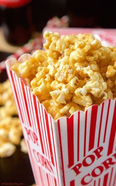 a red and white striped paper container filled with popcorn