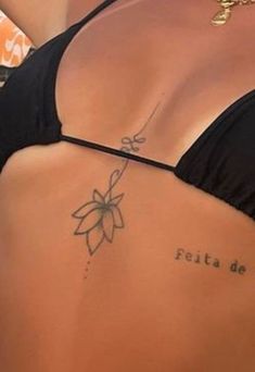 a woman with a tattoo on her lower back and the words fetta dei written in cursive writing