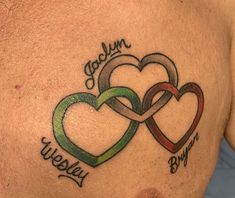 a couple of hearts that are on the back of a man's chest with words written below them