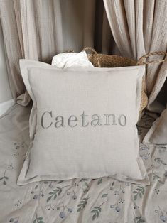 a white pillow with the word caetano written in cursive font on it