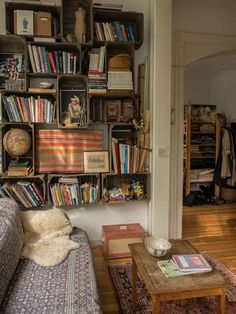 a living room filled with furniture and lots of bookshelves on top of it