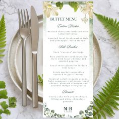 a place setting with silverware and green leaves on the table, along with a menu card