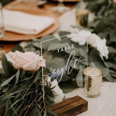 the table is set with flowers and greenery