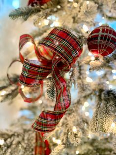 a christmas tree decorated with plaid ribbon and ornaments